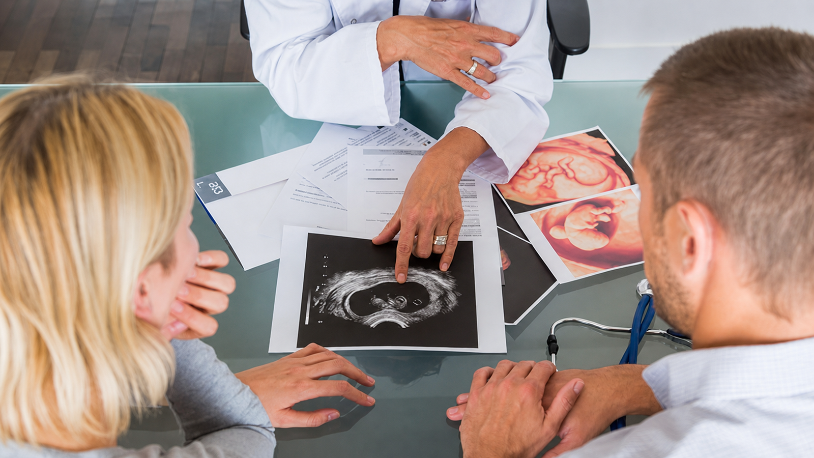 A physician reviewing ultrasound images with patients